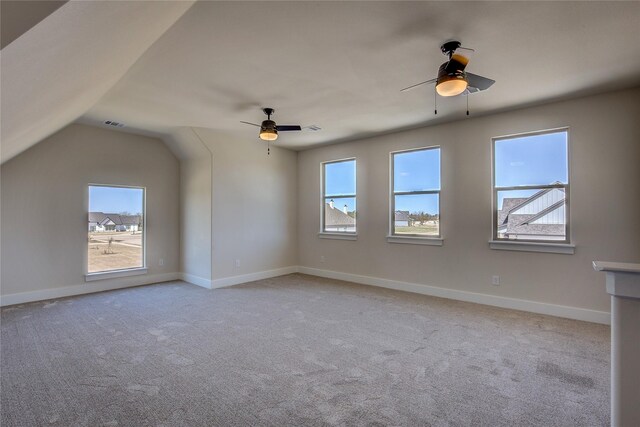 unfurnished room with ceiling fan, a wealth of natural light, and light carpet