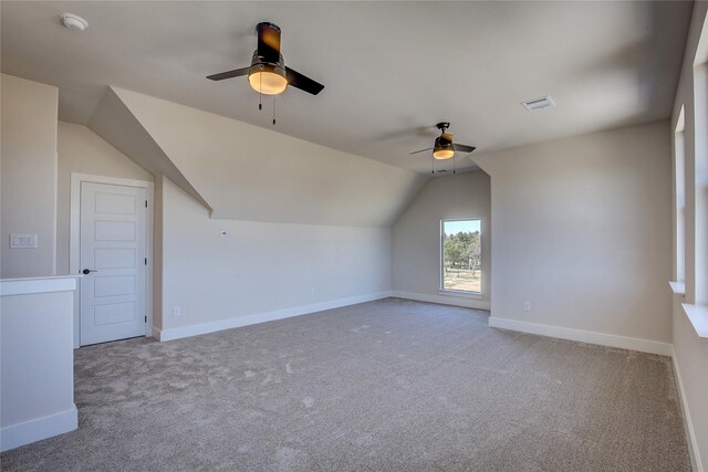 additional living space featuring carpet floors, ceiling fan, visible vents, and vaulted ceiling