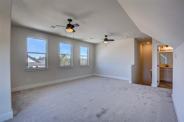 empty room with a ceiling fan, carpet, a healthy amount of sunlight, and visible vents