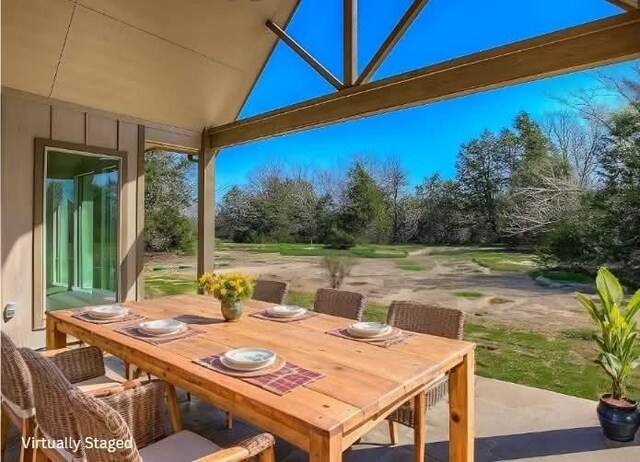 view of patio with glass enclosure and outdoor dining area
