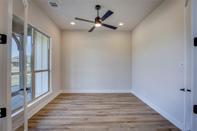 unfurnished room with baseboards, light wood-style flooring, ceiling fan, and visible vents