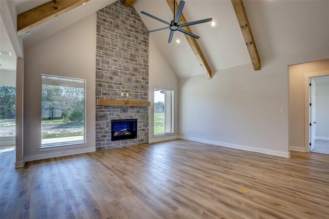 unfurnished living room featuring wood finished floors, baseboards, beamed ceiling, and ceiling fan