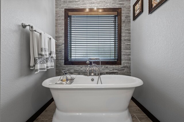bathroom with a freestanding tub and baseboards