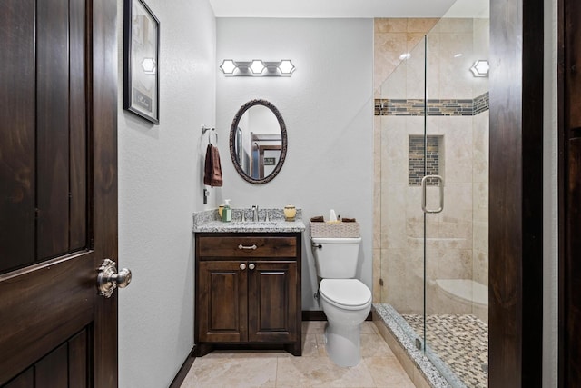full bathroom featuring toilet, a shower stall, vanity, and baseboards