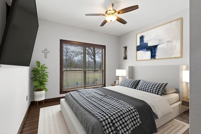 bedroom with ceiling fan, baseboards, and wood finished floors