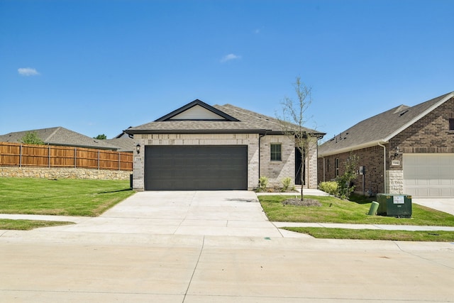 718 Caraway Dr, Princeton, TX 75071 - view of front of home featuring brick siding, a garage, driveway, and a shingled roof