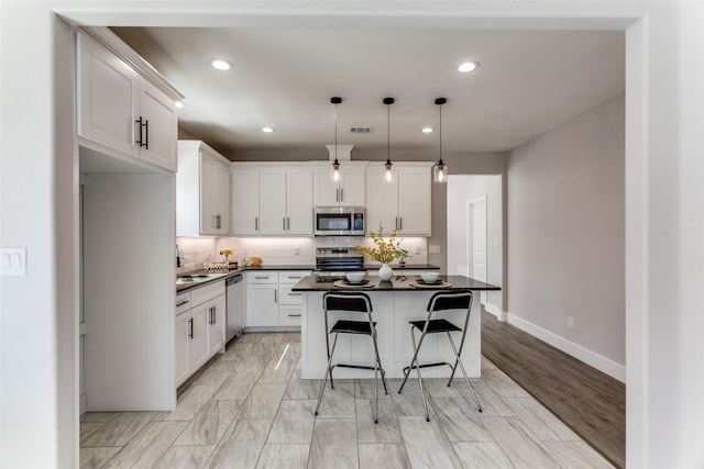 kitchen featuring marble finish floor, appliances with stainless steel finishes, backsplash, and a sink