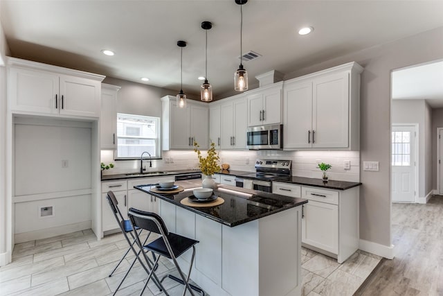 kitchen featuring a sink, visible vents, backsplash, appliances with stainless steel finishes, and plenty of natural light