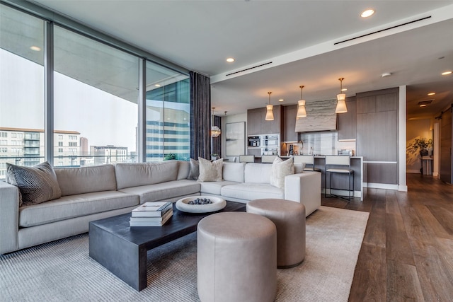 living room with recessed lighting, visible vents, and dark wood finished floors
