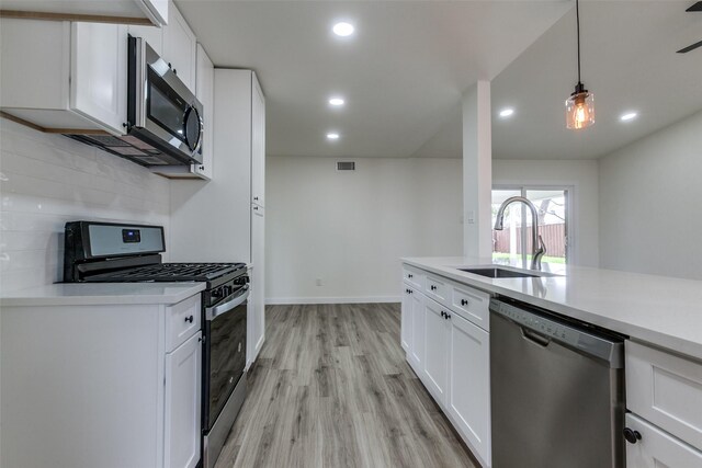 8212 Greenhollow Ln, Dallas, TX 75240 - kitchen featuring a sink, stainless steel dishwasher, baseboards, light wood finished floors, and white cabinets