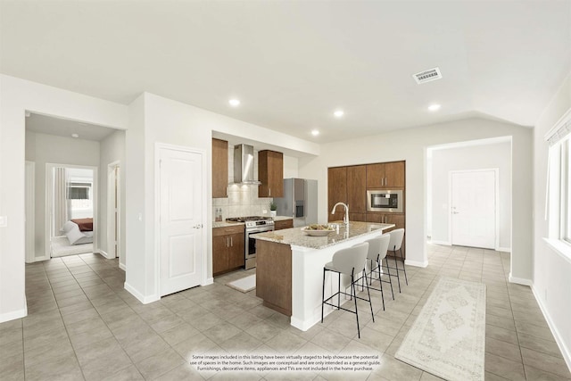 3255 Blossom Trl, Crandall, TX 75114 - kitchen with wall chimney exhaust hood, appliances with stainless steel finishes, an island with sink, backsplash, and a breakfast bar