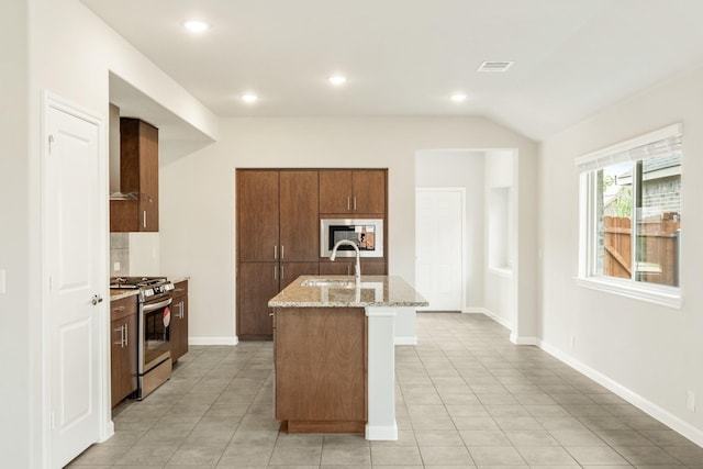 3255 Blossom Trl, Crandall, TX 75114 - kitchen with stainless steel range with gas cooktop, a sink, light stone countertops, wall chimney range hood, and a center island with sink