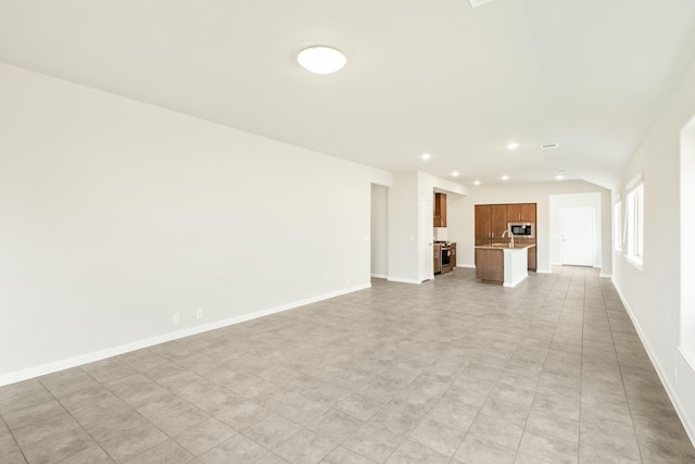 3255 Blossom Trl, Crandall, TX 75114 - unfurnished living room with recessed lighting, baseboards, and a sink