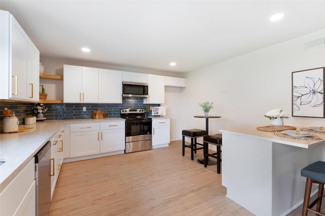 kitchen with visible vents, open shelves, stainless steel appliances, decorative backsplash, and light countertops