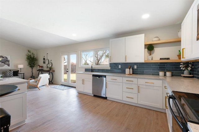 kitchen featuring open shelves, decorative backsplash, light countertops, stainless steel dishwasher, and light wood-type flooring
