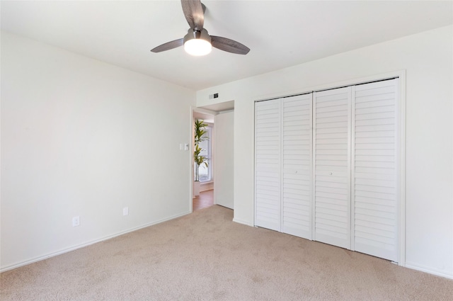 unfurnished bedroom with ceiling fan, a closet, and light carpet