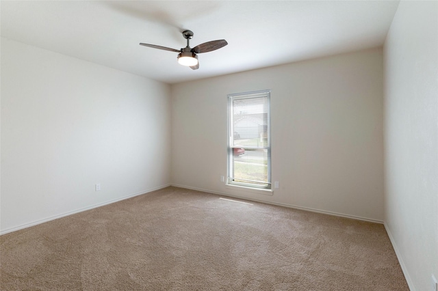 carpeted empty room with baseboards and a ceiling fan