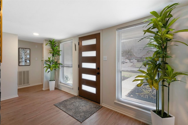 entrance foyer featuring light wood-style floors, visible vents, and baseboards
