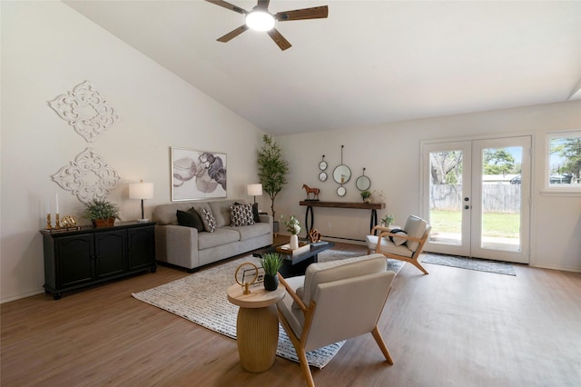 living room featuring a ceiling fan, baseboards, light wood finished floors, lofted ceiling, and french doors