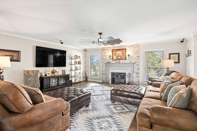 living room featuring ceiling fan, wood finished floors, ornamental molding, and a fireplace