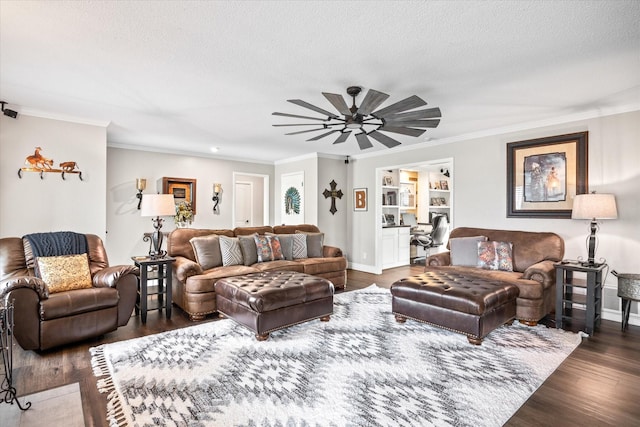 living room with ceiling fan, ornamental molding, dark wood-style flooring, and a textured ceiling