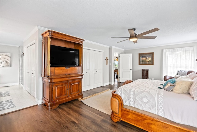bedroom featuring two closets, crown molding, ceiling fan, wood finished floors, and a textured ceiling