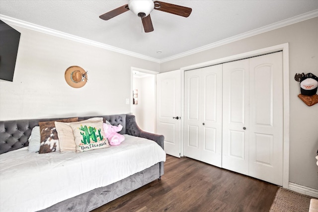 bedroom with a closet, crown molding, dark wood-type flooring, and ceiling fan