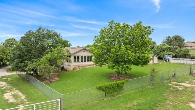 view of yard featuring an outbuilding, a fenced backyard, and a shed
