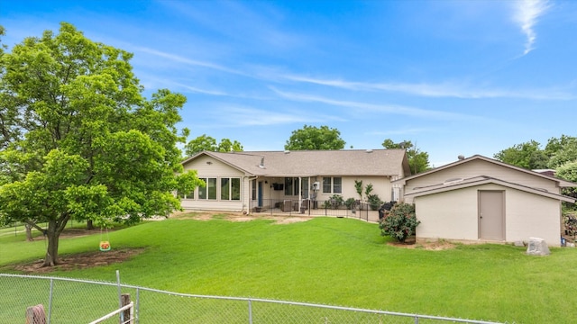 back of house featuring a patio area, a lawn, an outdoor structure, and fence