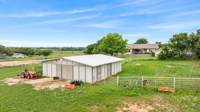 view of yard featuring an outbuilding, a rural view, a garage, and fence