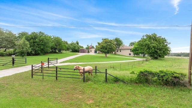 surrounding community with a yard, a rural view, and fence