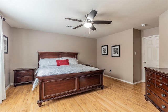 bedroom featuring baseboards, ceiling fan, light wood-type flooring, and visible vents
