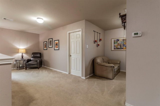 living area with carpet floors, baseboards, and visible vents