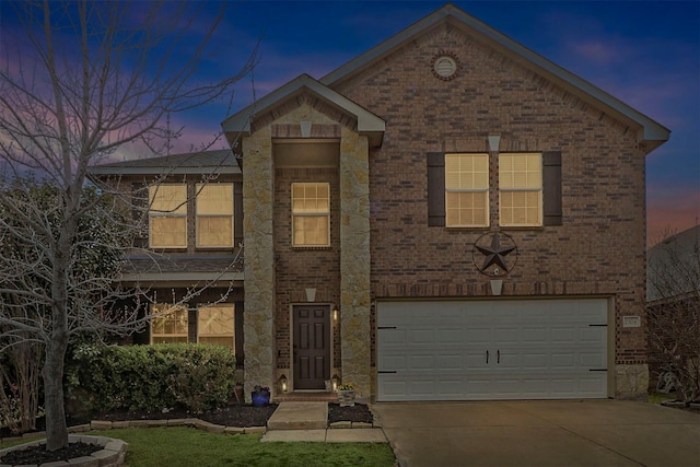 traditional-style house featuring an attached garage, concrete driveway, and brick siding