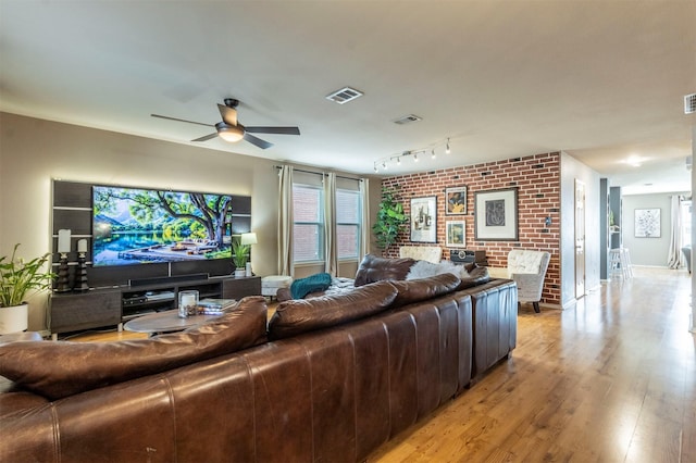 living area featuring a wealth of natural light, ceiling fan, light wood-type flooring, and visible vents