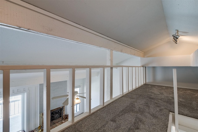 interior space with lofted ceiling, ceiling fan, and carpet floors