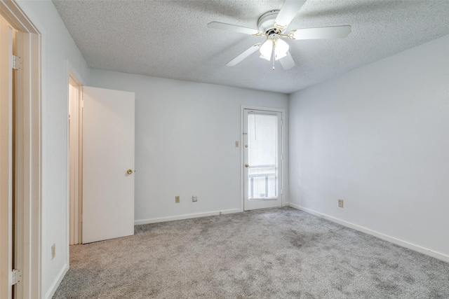 carpeted empty room featuring baseboards, a textured ceiling, and ceiling fan