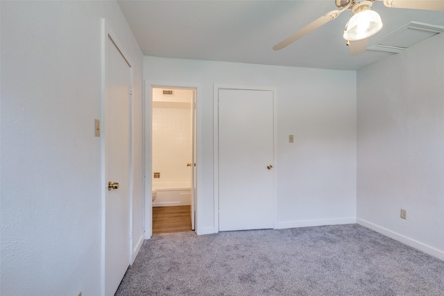 unfurnished bedroom featuring visible vents, baseboards, carpet flooring, ensuite bathroom, and a ceiling fan