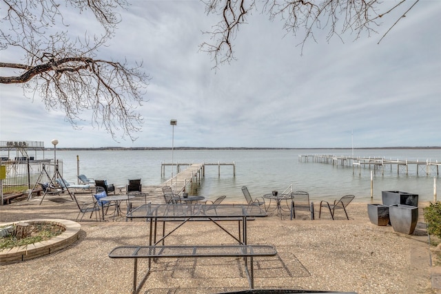 view of dock featuring a patio area and a water view