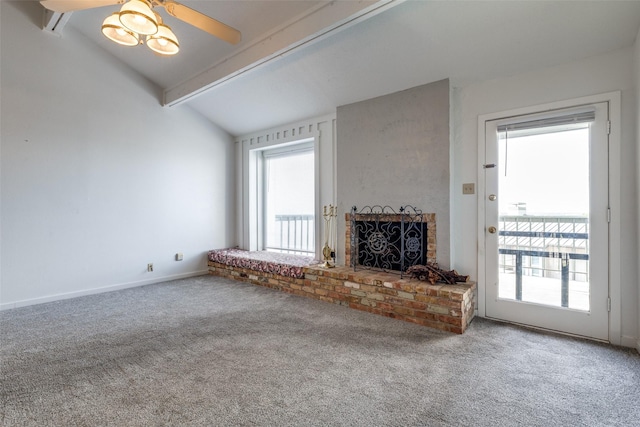 unfurnished living room featuring baseboards, lofted ceiling with beams, carpet floors, a fireplace, and a ceiling fan