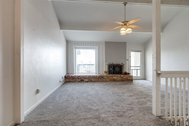 unfurnished living room with ceiling fan, a brick fireplace, baseboards, and carpet floors