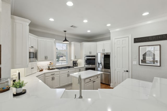 kitchen featuring visible vents, ornamental molding, a sink, appliances with stainless steel finishes, and white cabinetry