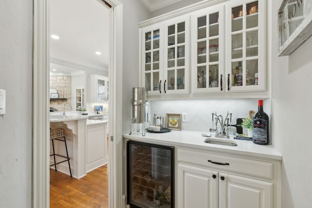 bar with a sink, indoor wet bar, tasteful backsplash, and beverage cooler