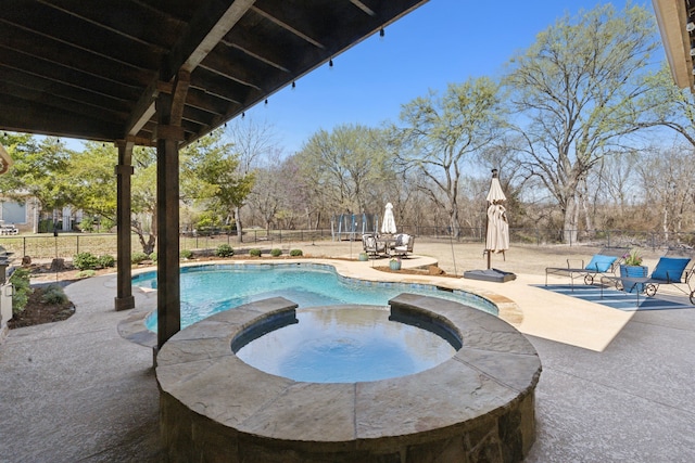 view of swimming pool with a pool with connected hot tub, a fenced backyard, and a patio area