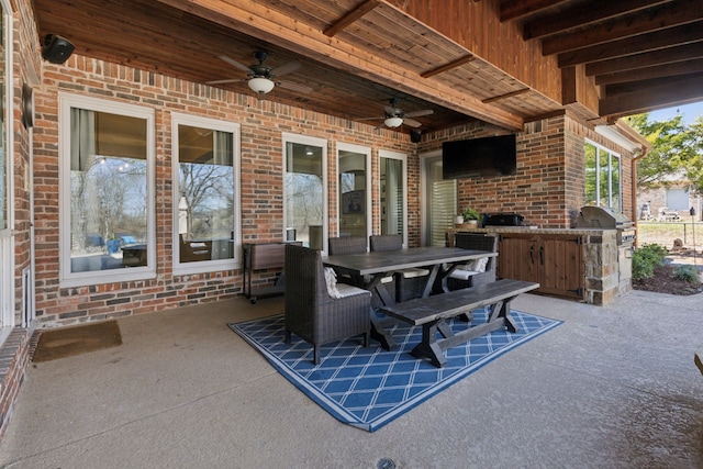 view of patio with outdoor dining space, an outdoor kitchen, a grill, and ceiling fan