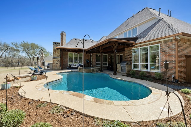 view of pool with a pool with connected hot tub, a grill, and a patio area