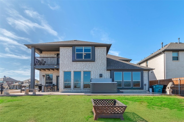 1411 Fishergate Dr, Forney, TX 75126 - back of house with a balcony, a patio area, a hot tub, a fire pit, and a shingled roof
