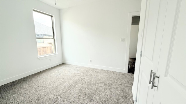 unfurnished bedroom featuring carpet floors and baseboards