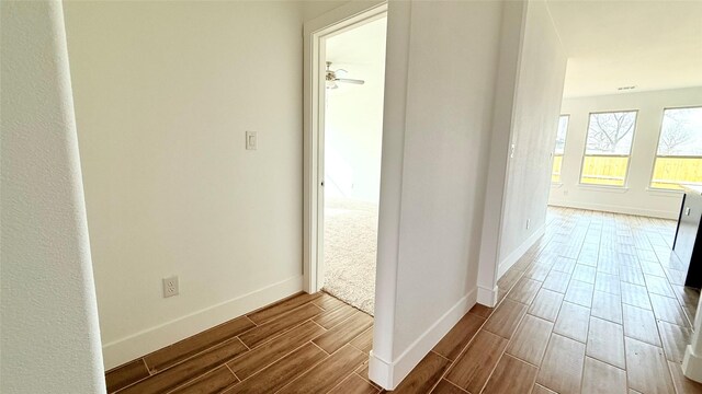 hall featuring wood finish floors and baseboards