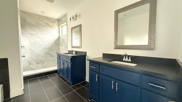 bathroom featuring two vanities, tile patterned flooring, a sink, and tiled shower